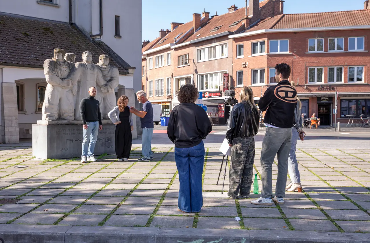 Mensen worden gefilmd voor het standbeeld van Daens in Aalst