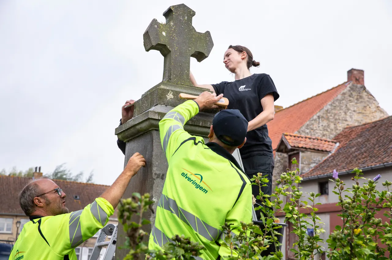 Vrijwilligers poetsen het gedenkteken WOI in Alveringem